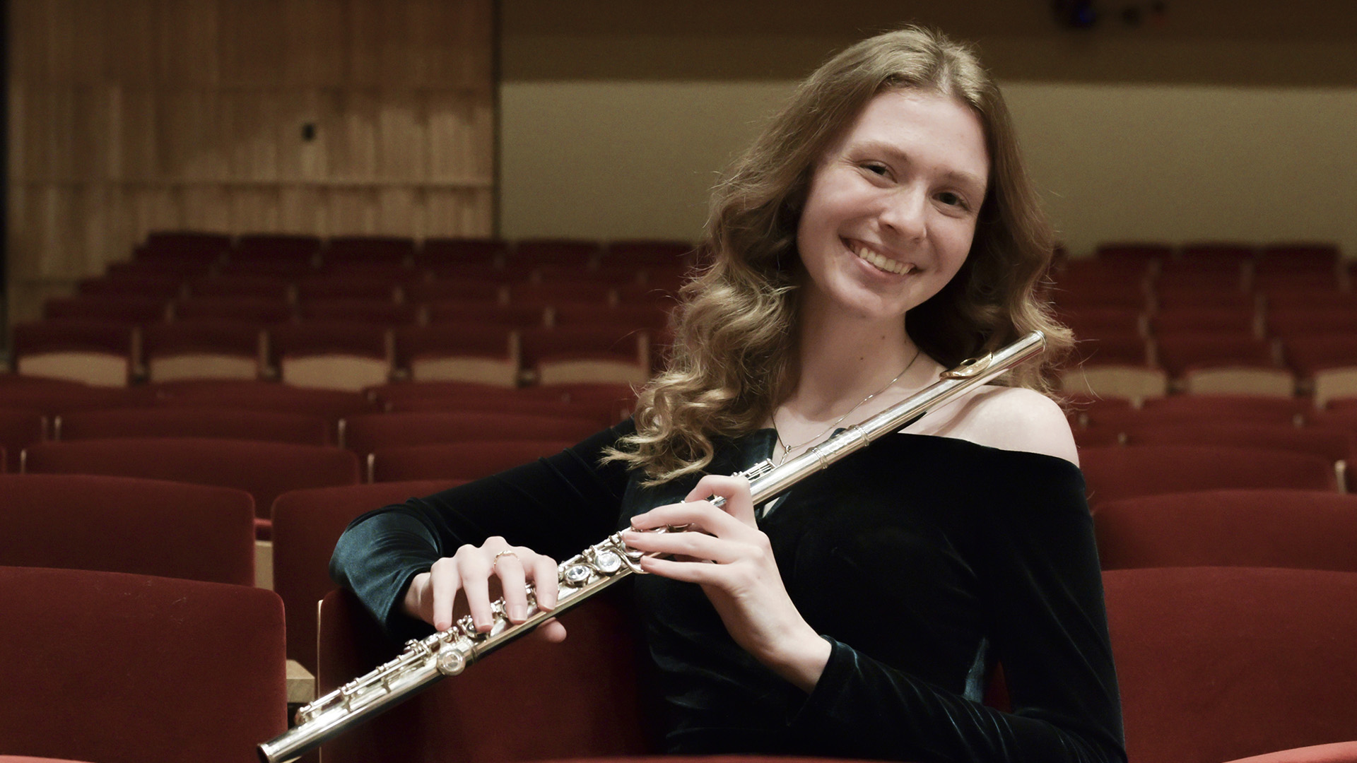 Isabelle Haugen holds a flute while sitting in the seats for the VCSU Performance Hall.