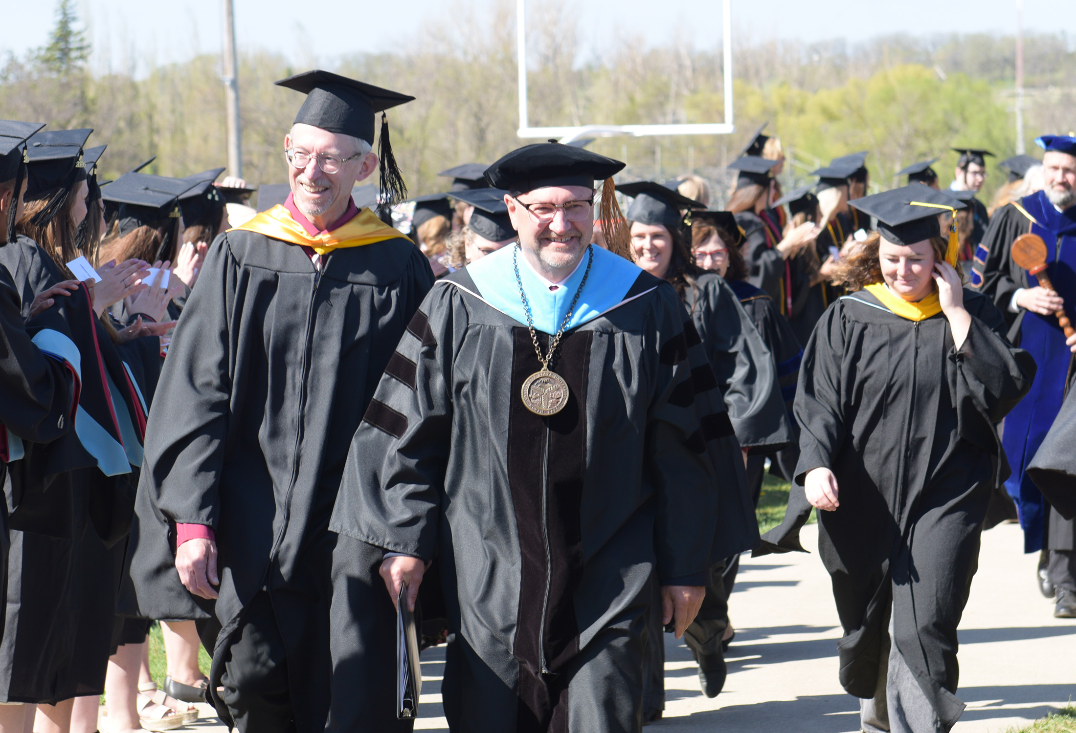 Dr. Allen Burgad, dressed in academic regalia, leads VCSU faculty and staff during the walk into commencement.