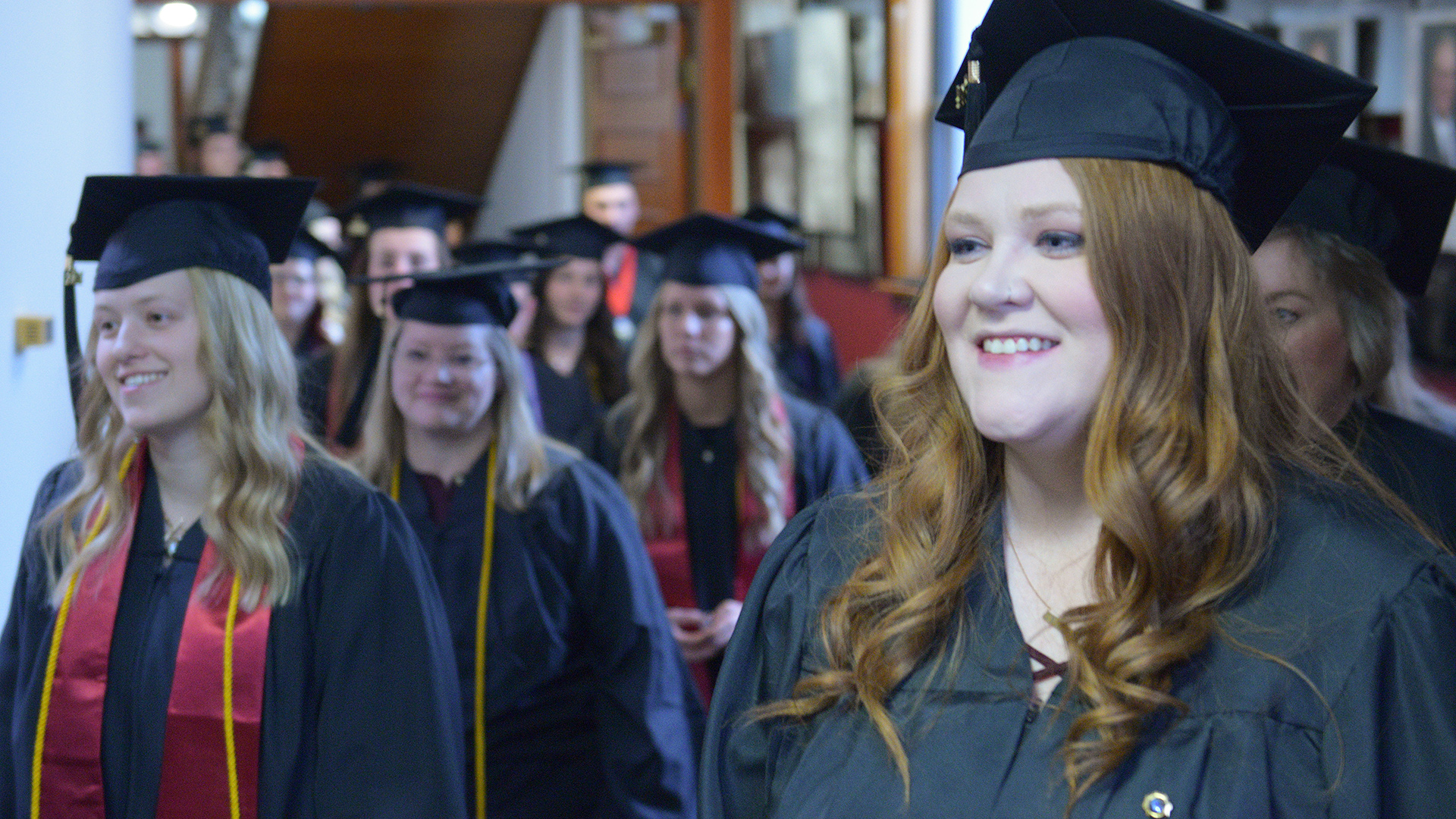 Graduates in caps and gowns walk into the VCSU Winter Commencement