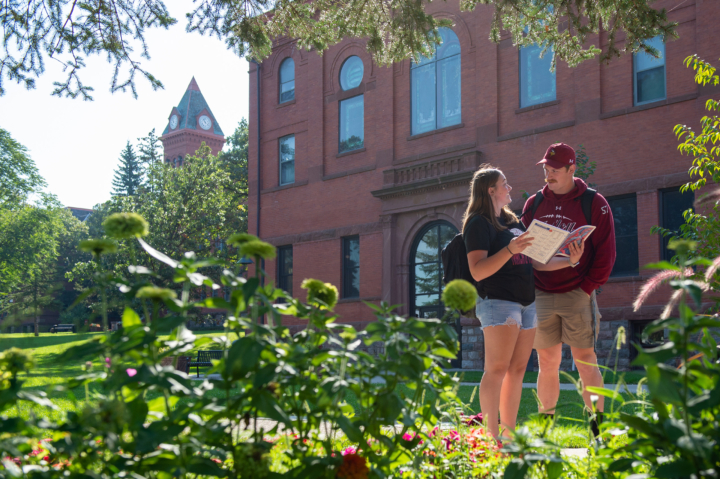 Two students stand in front of Vangstad Auditorium .
