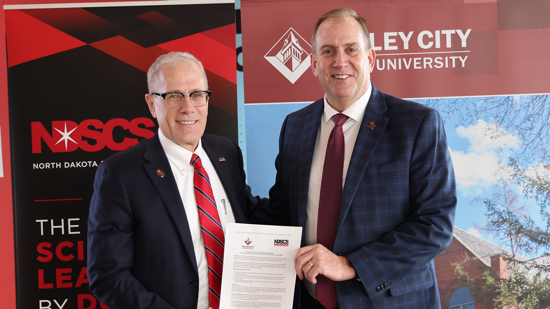 VCSU President Dr. Alan LaFave and NDSCS President Dr. Rod Flanigan hold up the articulation agreement.