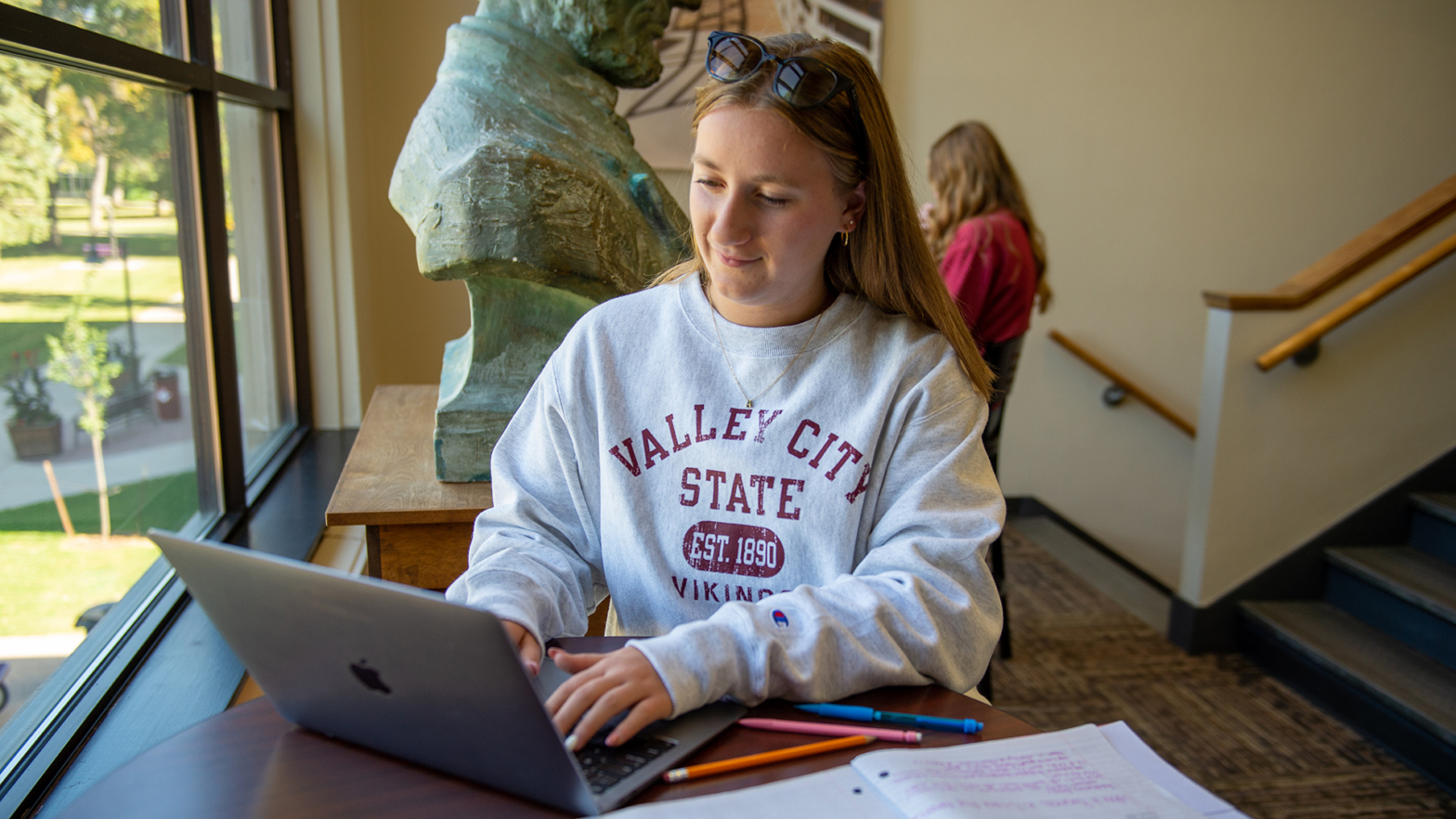 A female student does classwork on her laptop