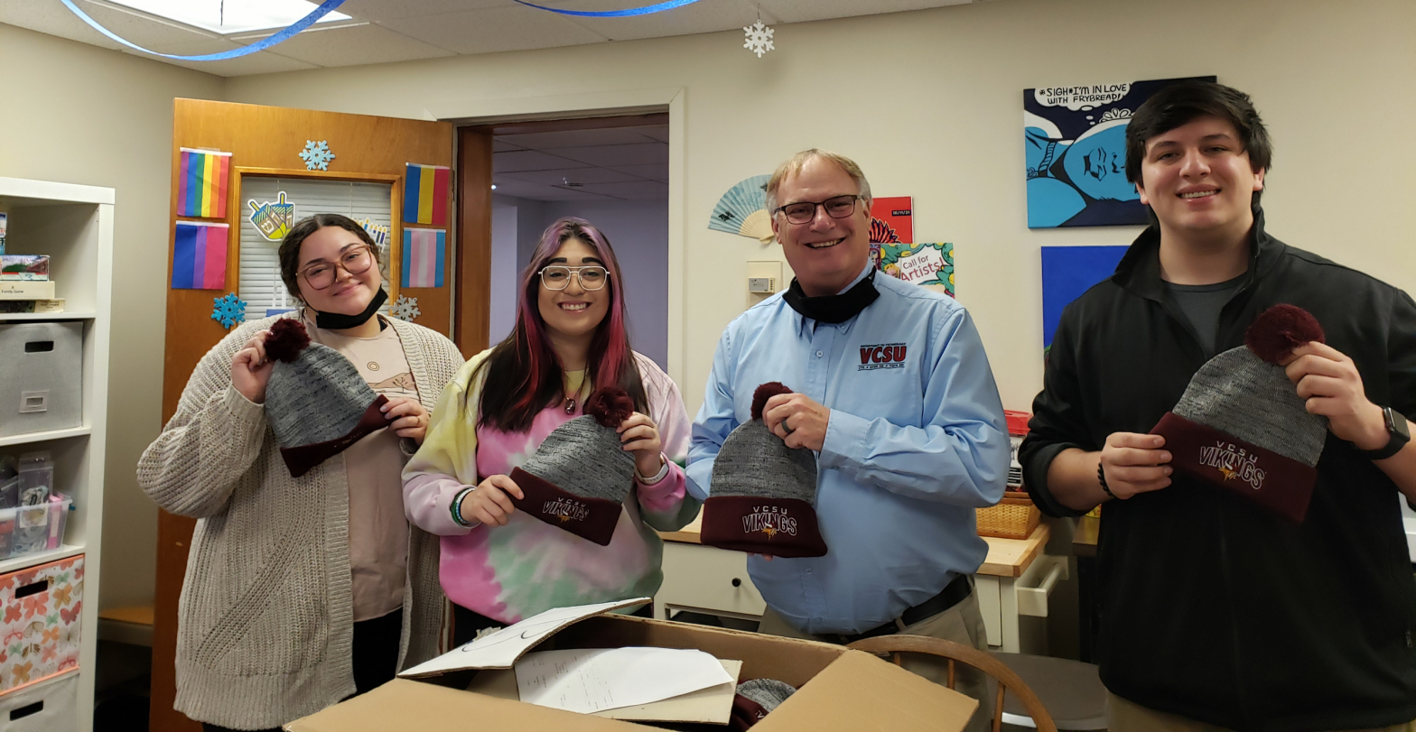Students receiving hats from Rick Ross
