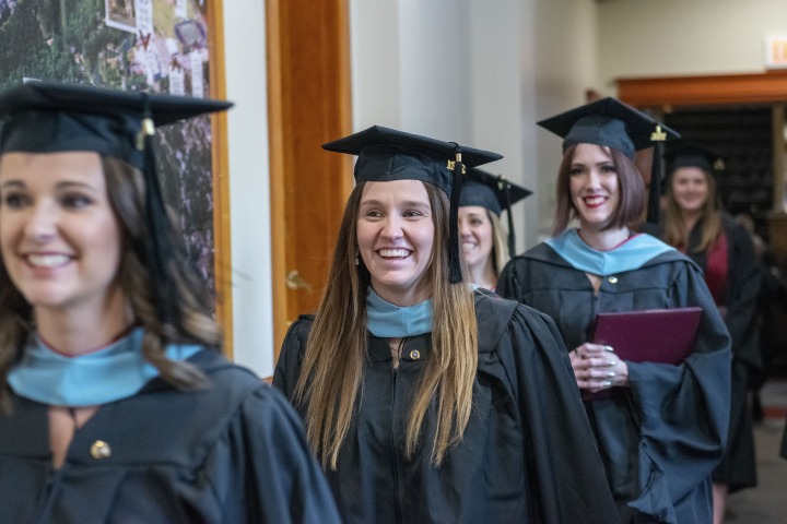 Graduates line up in McFarland Hall preparing for commencement ceremonies in Vangstad Auditorium. 