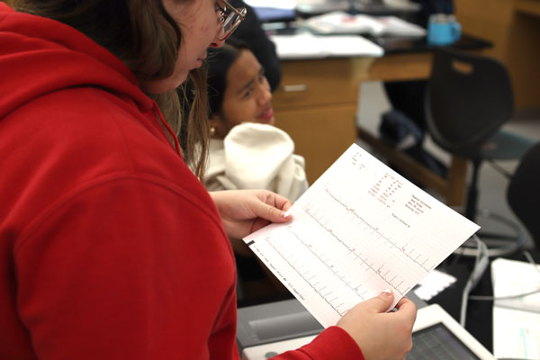 Image of a student working with an EKG reading strip to look at heart rate.