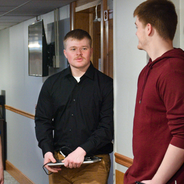 Connor Aanderud talking with classmates and professor