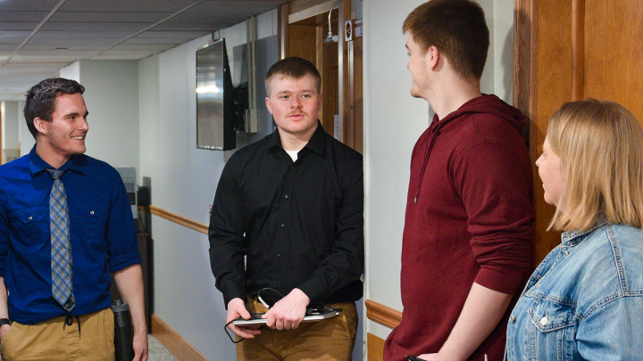 Connor Aanderud talking with classmates and professor