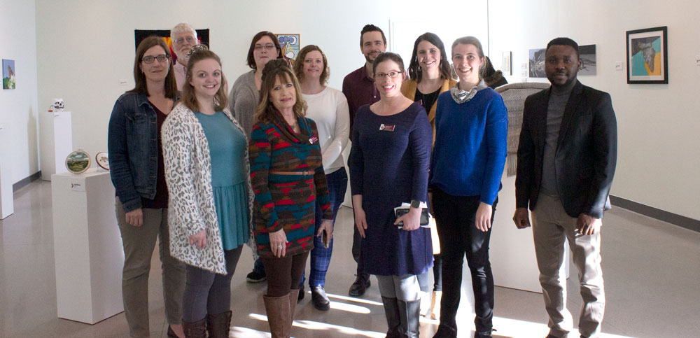 Faculty and staff who have pieces shown in the art gallery stand together.