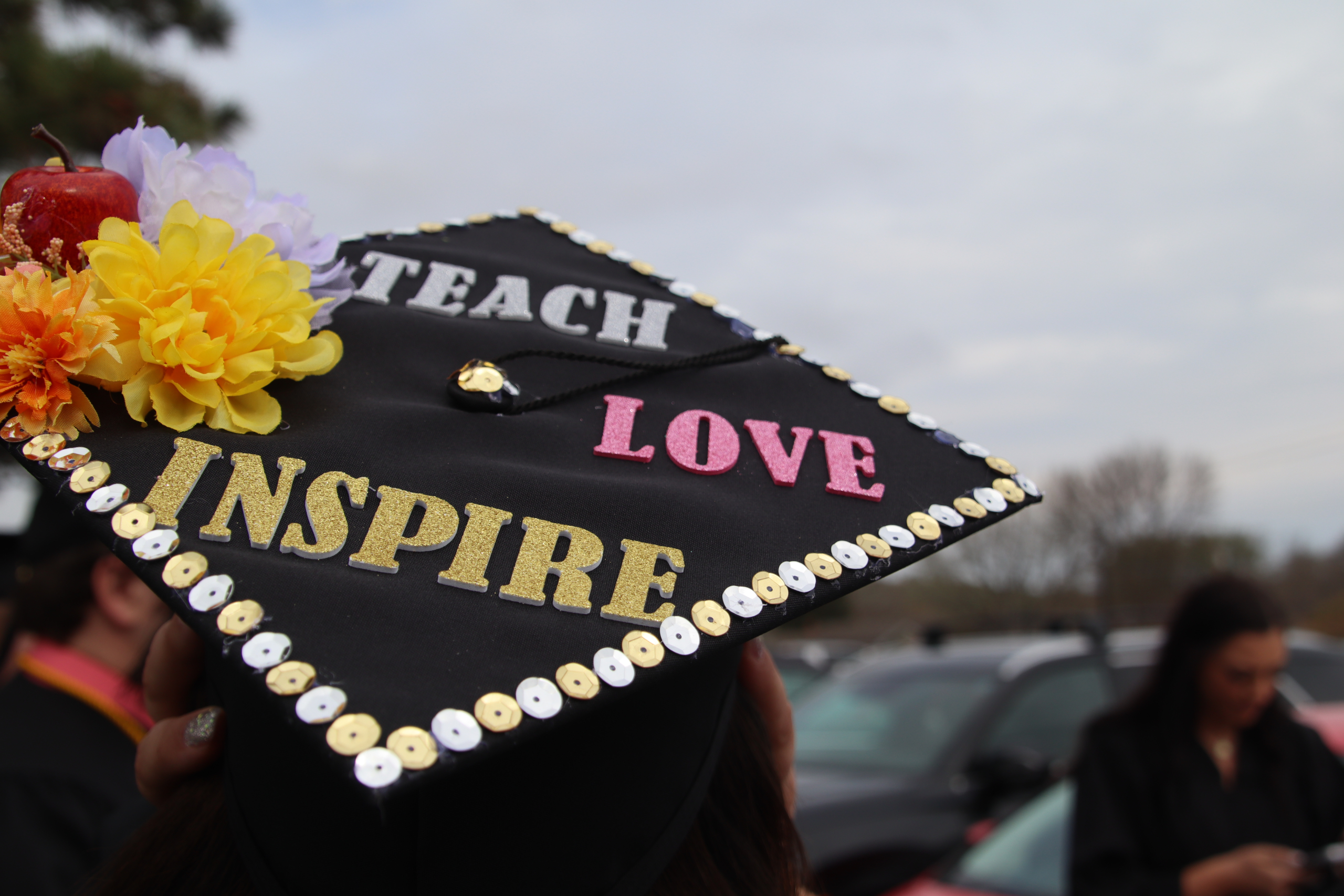 A graduation board with Teach, Love, Inspire written on the top.