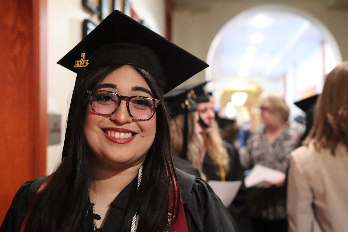 A VCSU Graduate stands in the hallway of McFarland Hall
