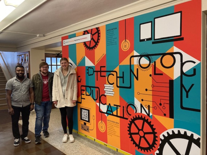 Ekow Ephrim, Jared Grommesh, Baily Nelson standing near art installation