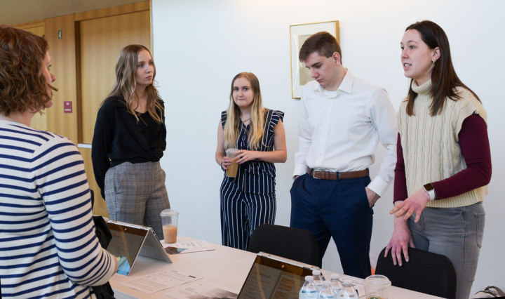 Business students explain their research project during the scholar symposium