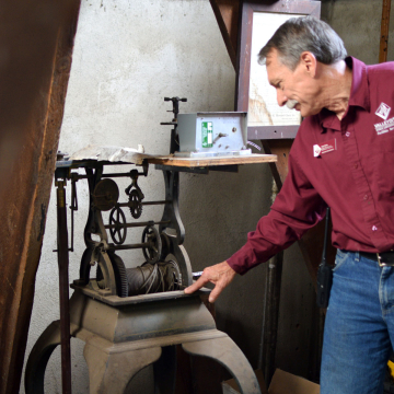 Daryl Heise, VCSU Facility Services, looks at the old time-keeping equipment in the clock tower.