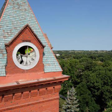 Workers begin to remove the old glass clock at the top of the clock tower. 