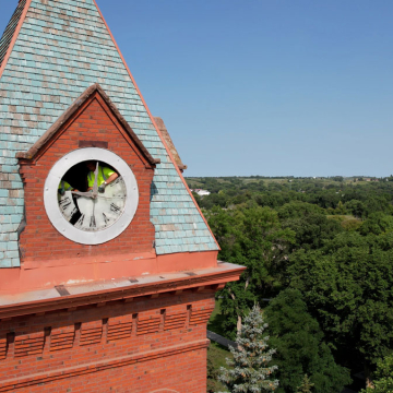 Workers begin to remove the old glass clock at the top of the clock tower.