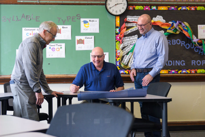 Three education faculty review an assignment submitted by a student. 