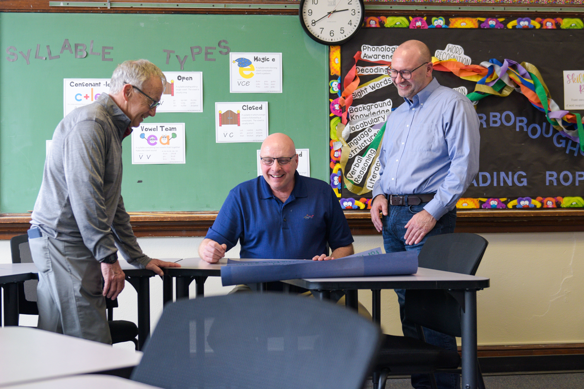 Three education faculty review an assignment submitted by a student. 