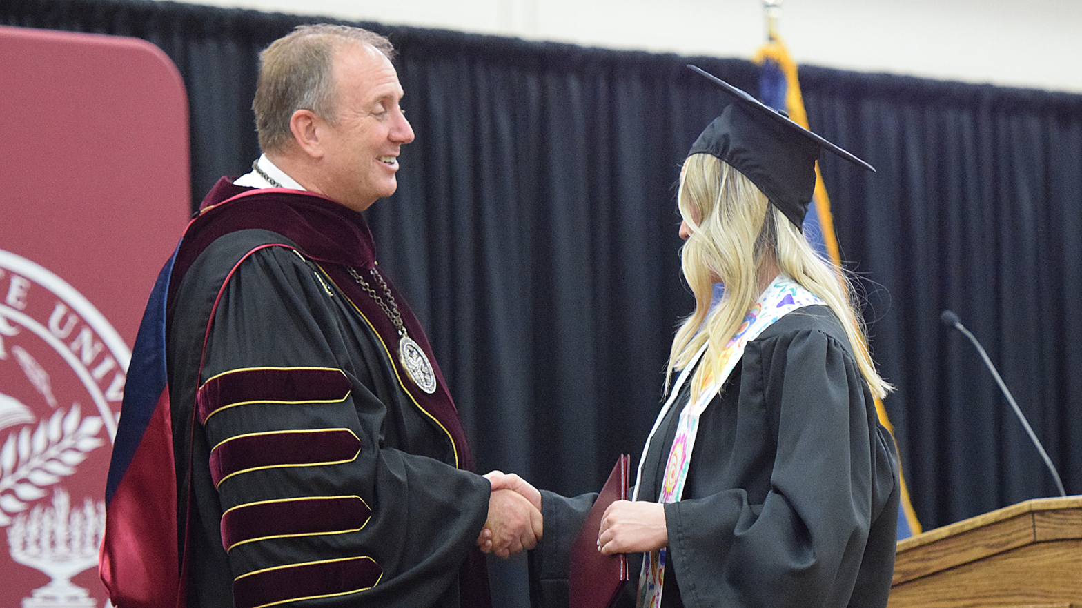 VCSU President Alan LaFave shakes hands with a student after they received a diploma at commencement
