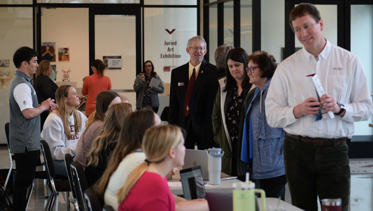 Students present information during the scholar symposium in the lobby of the Robinson Center for the Arts