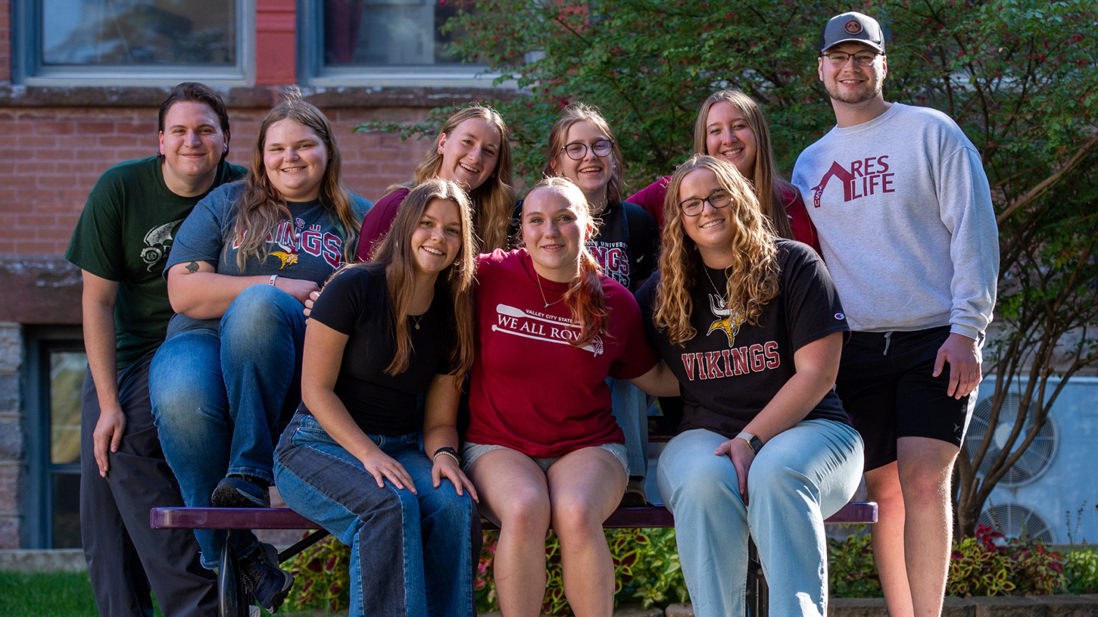 A group of 9 VCSU students stand in a group and smile at the camera