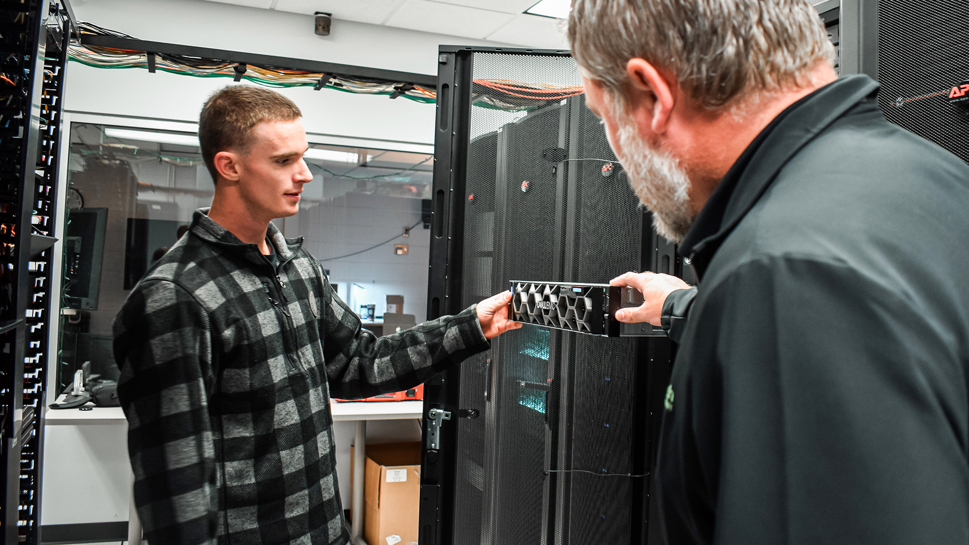 A VCSU student works technology services department, examining IT equipment