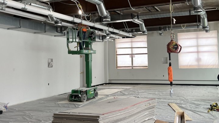 A 3rd floor classroom is shown with a lift for working on the ceiling; the carpet is laid but covering in protective plastic.