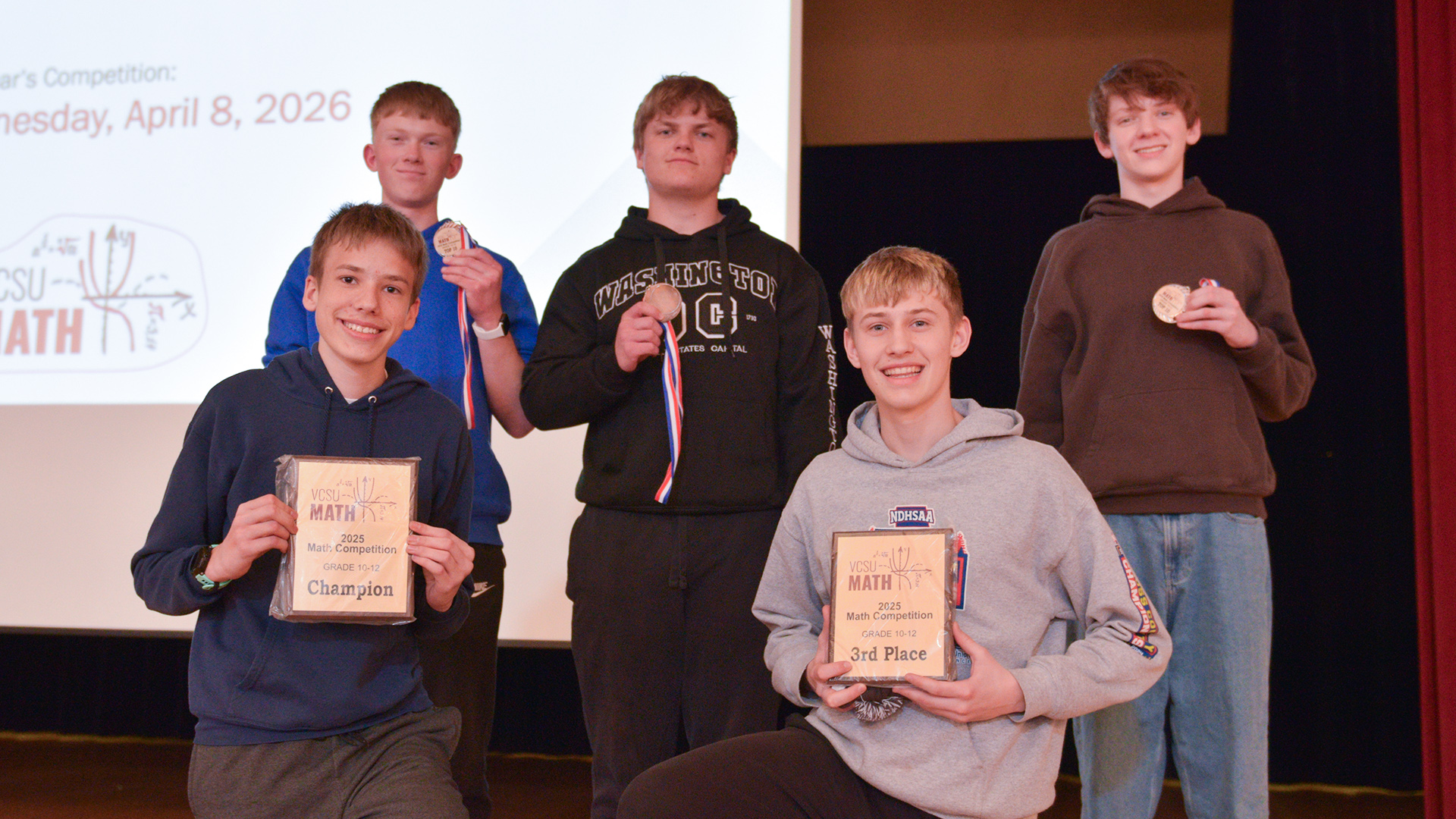 Five students hold plaques and medals for individual awards