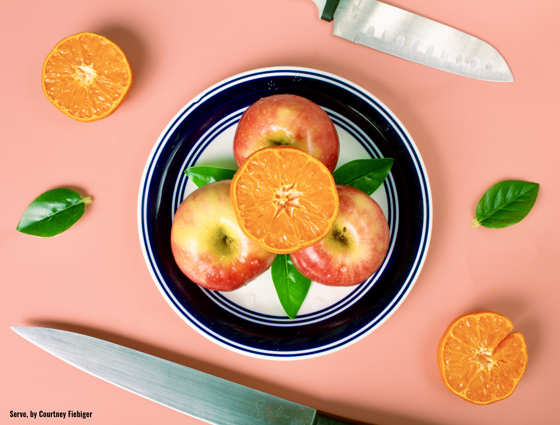 A piece titled "Serve" by Courtney Fiebiger, shows oranges and apples arranged neatly on a plate and table