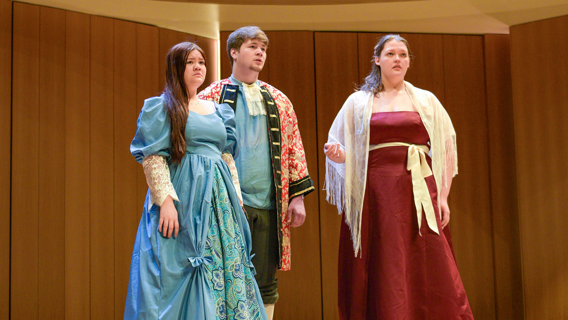 Three VCSU students students on stage singing during a previous opera ensemble concert.