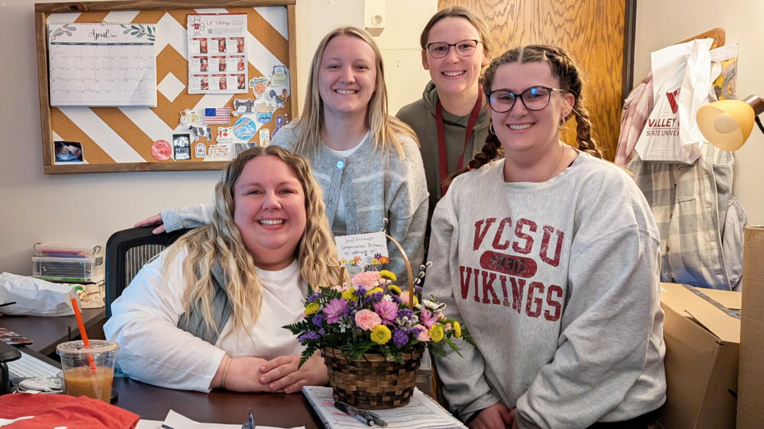 Brittany Nathan is presented a bouquet of flowers by 3 members of Student Senate