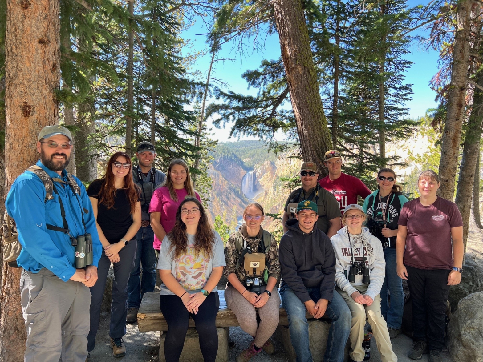 A group of 13 VCSU students and employees enjoy a shaded spot under the trees during a trip to Yellowstone National Park.