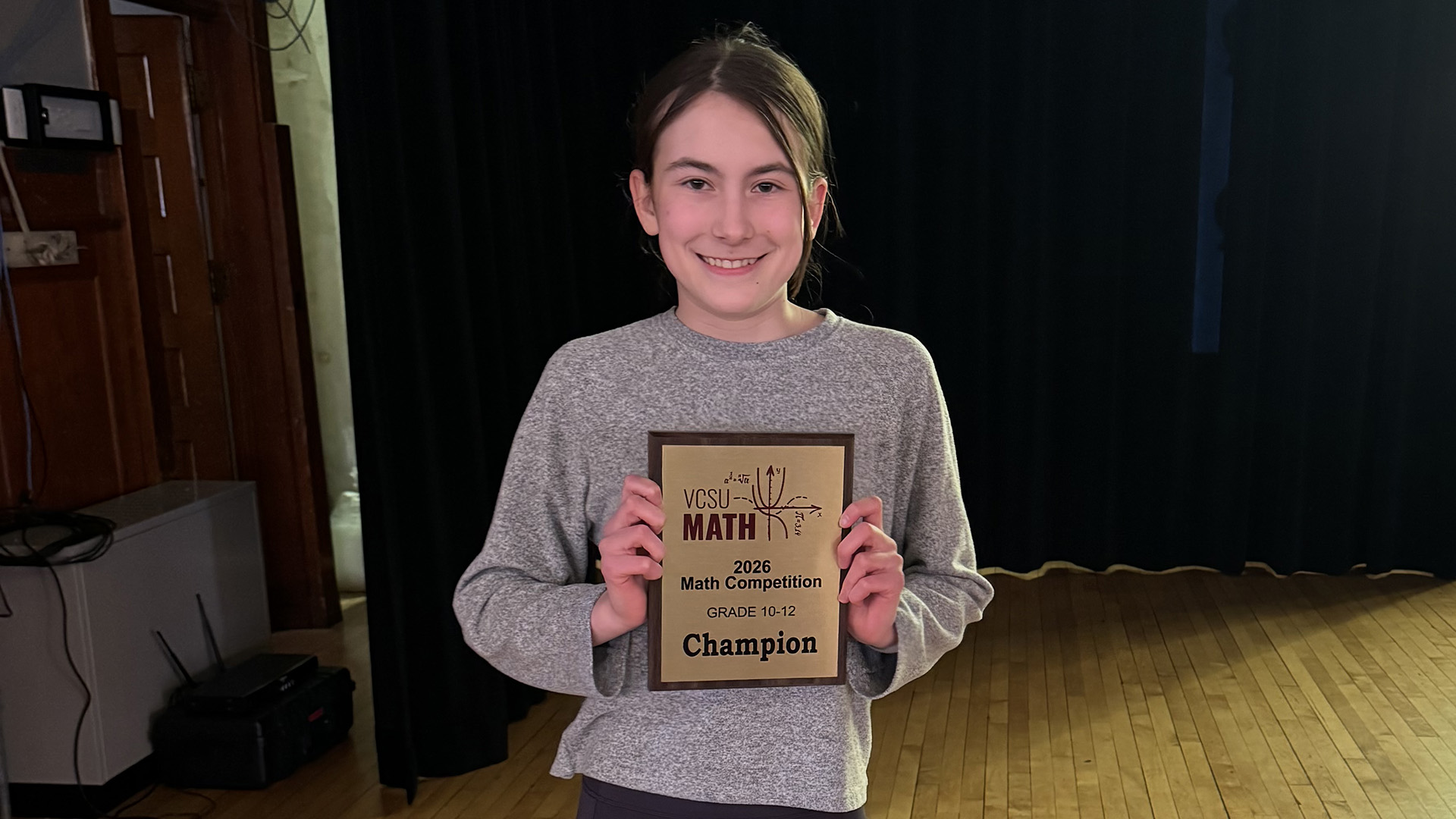 A female student holds up a first place plaque