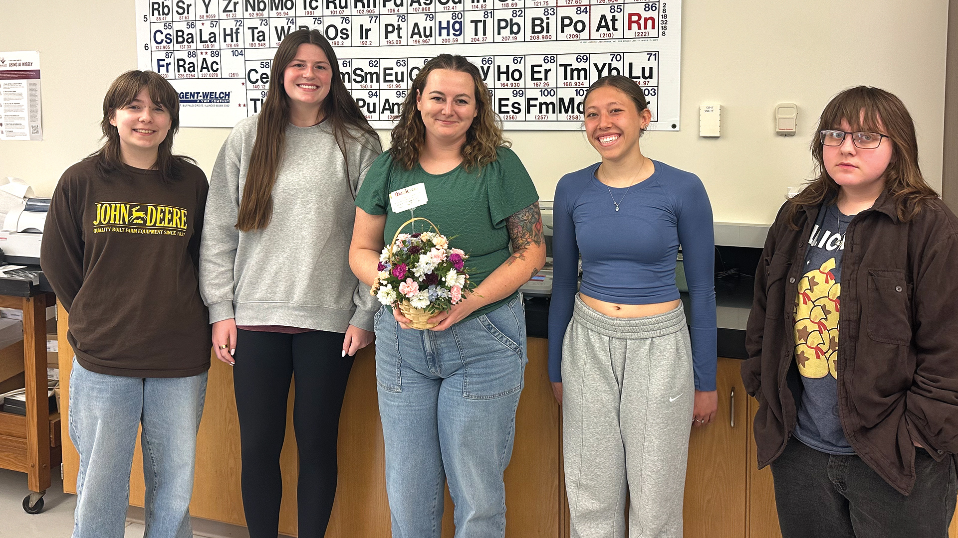 4 students present a bouquet of flowers to Lindsey Kiecker
