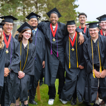 Group of graduates smiling at the camera outside