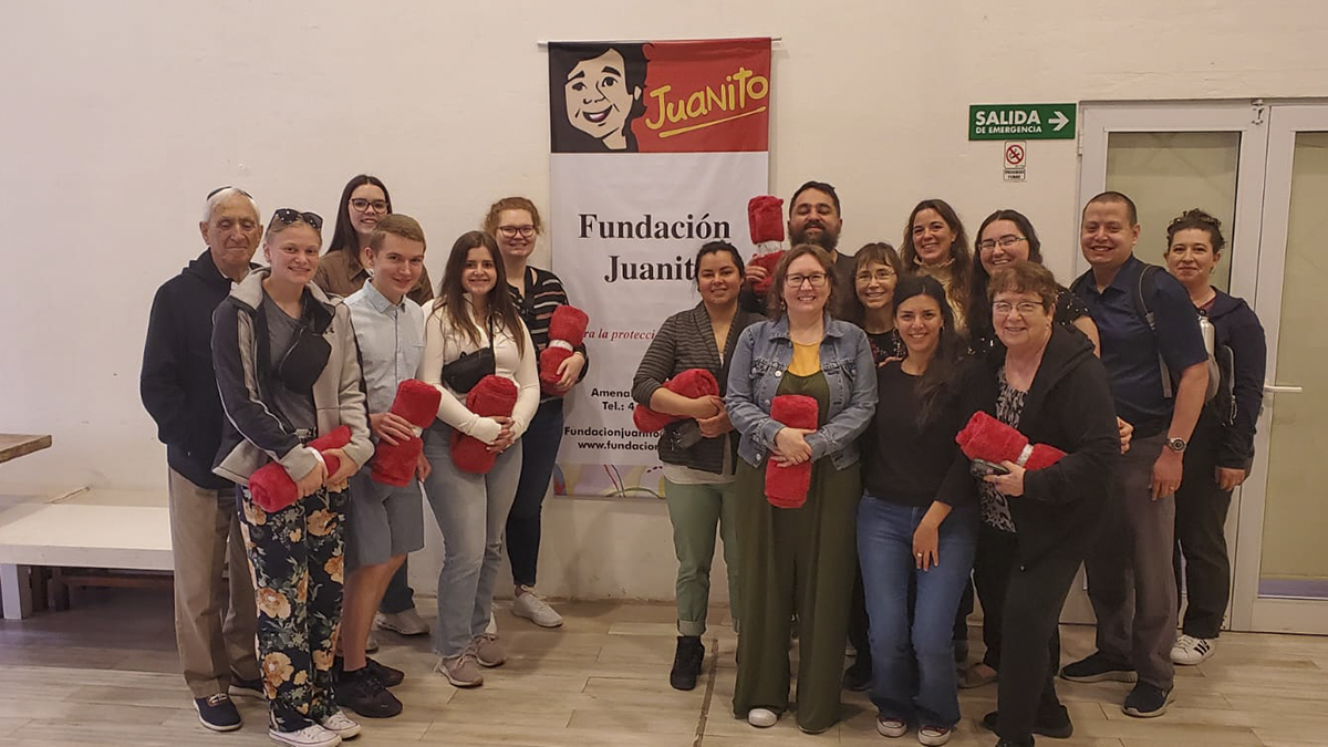 group posing with red blankets at organization