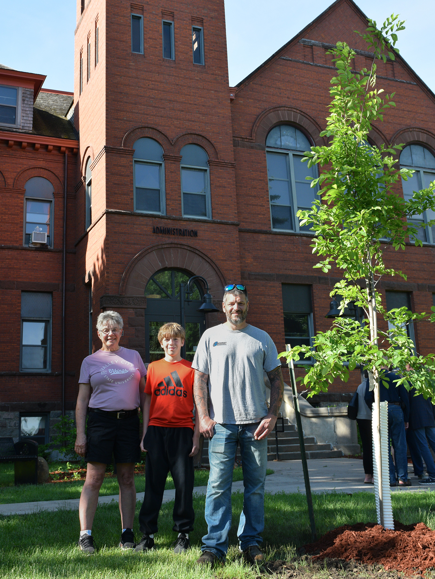Larry Robinson's family members pose for a picture near the tree planted in his honor