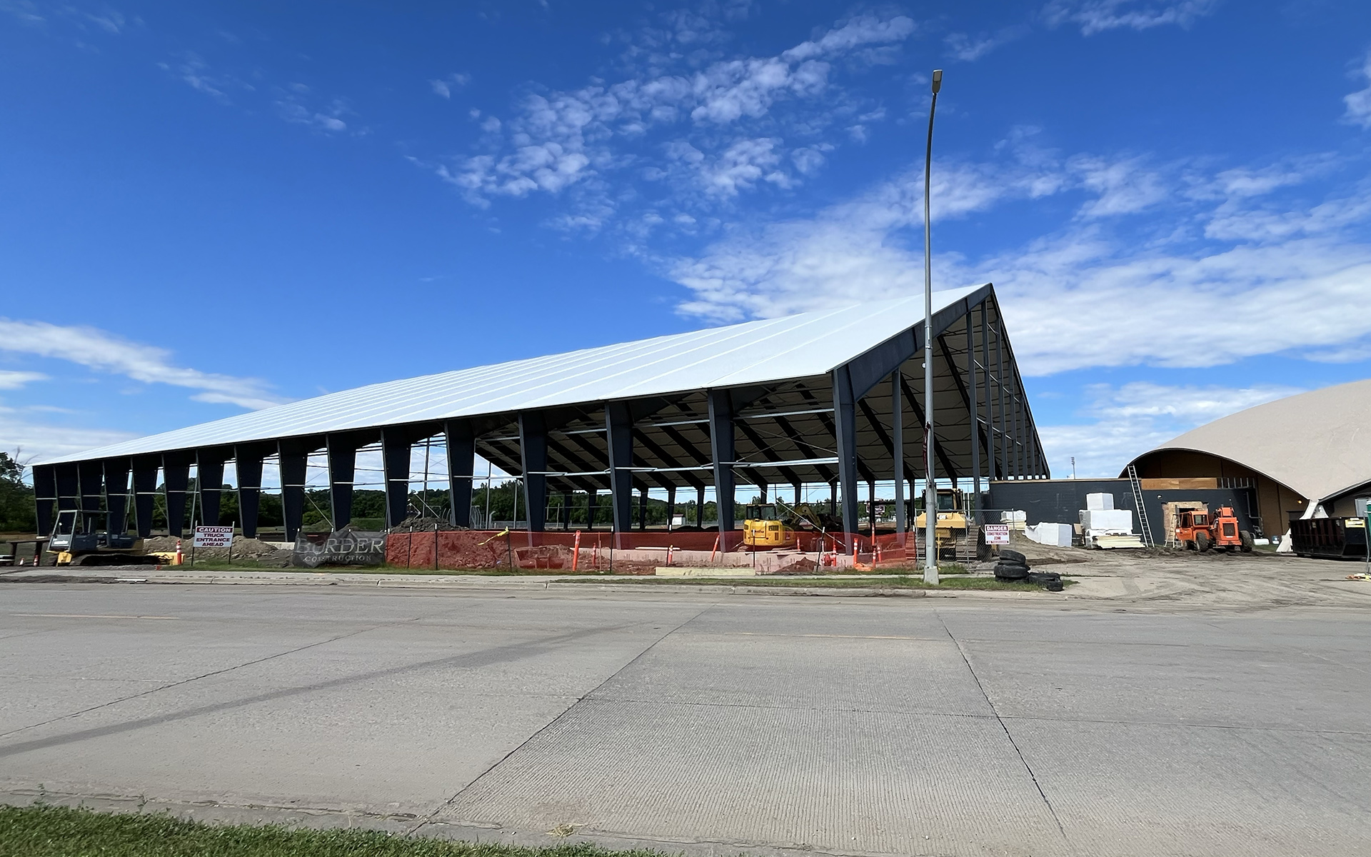 An exterior shot of the Tharaldson Family Athletic Center showing a construction site, a steel beam frame and a white roof