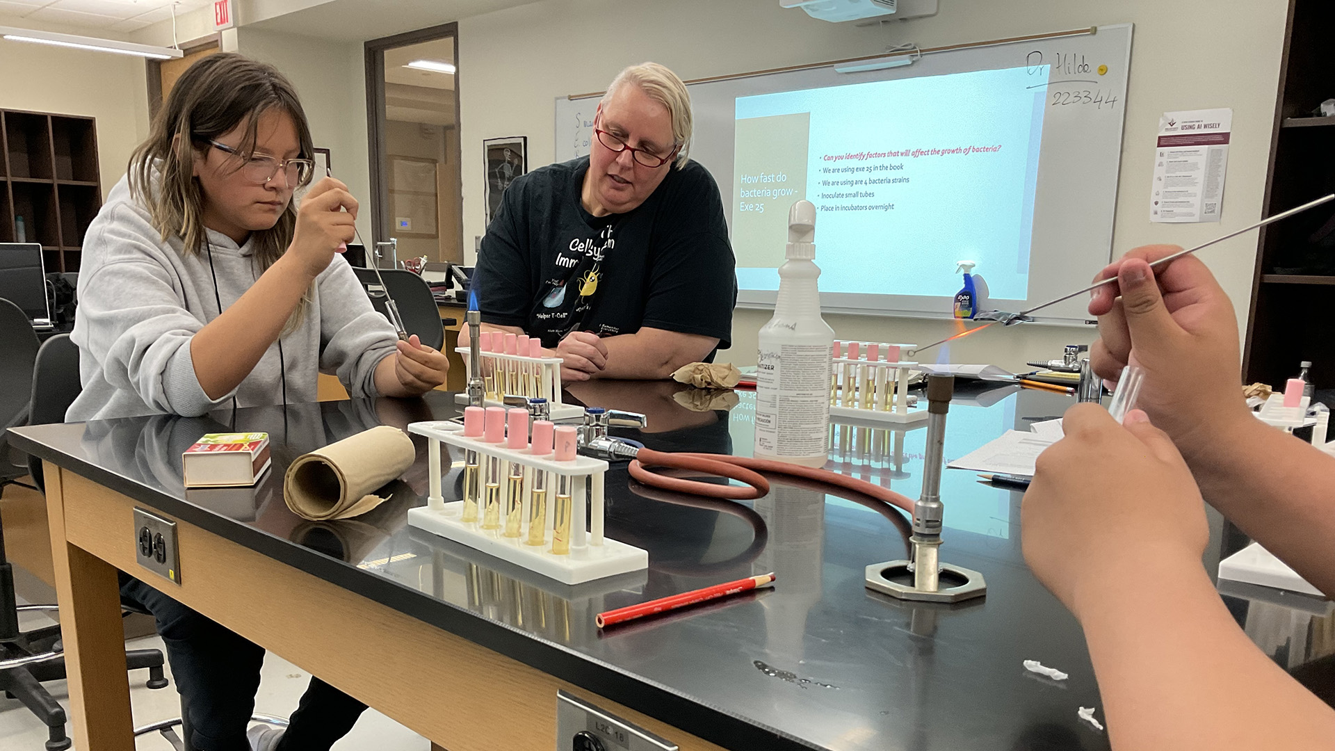 A student works in a science lab with test tubes and a bunsen burner.