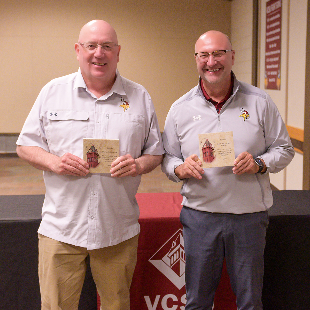 Dennis McCulloch and Allen Burgad hold up stone donor awards