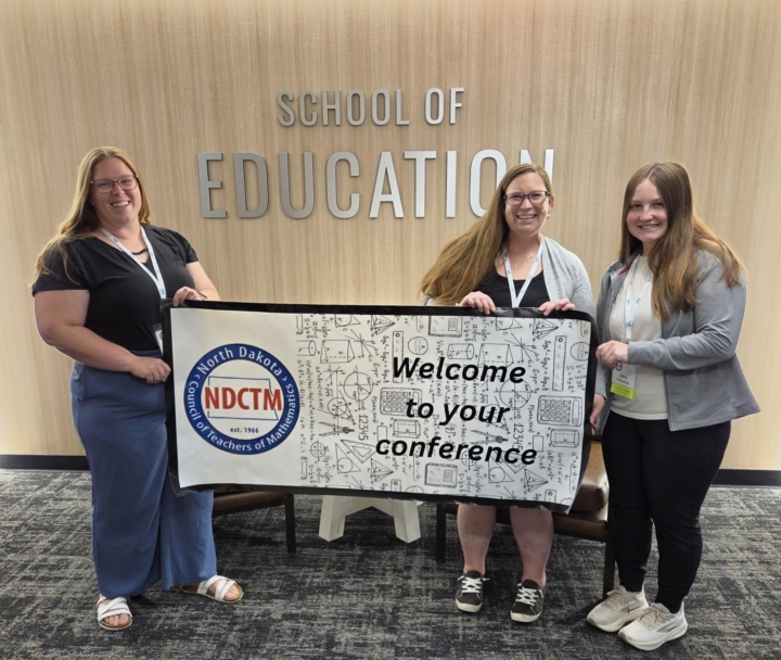 professors and student holding banner