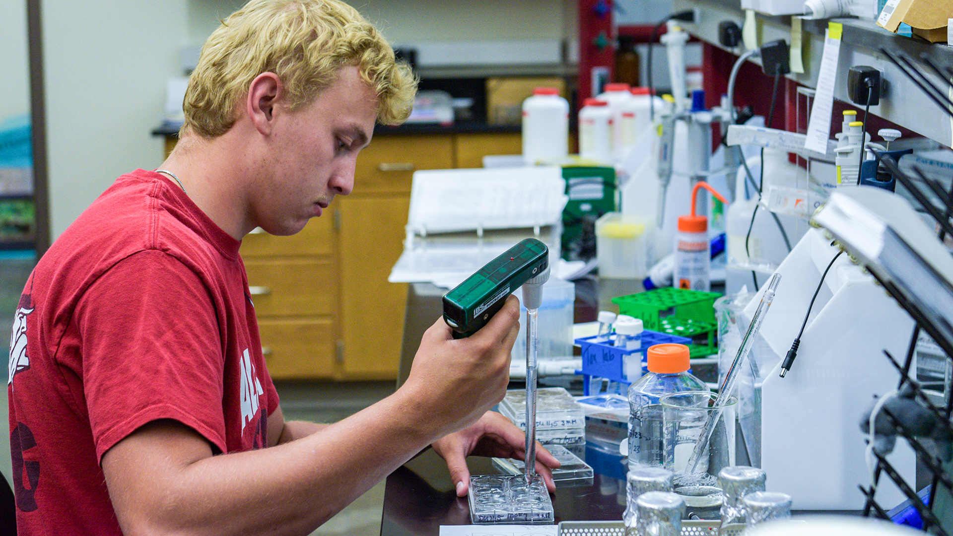 A male student works in a research lab on the VCSU campus