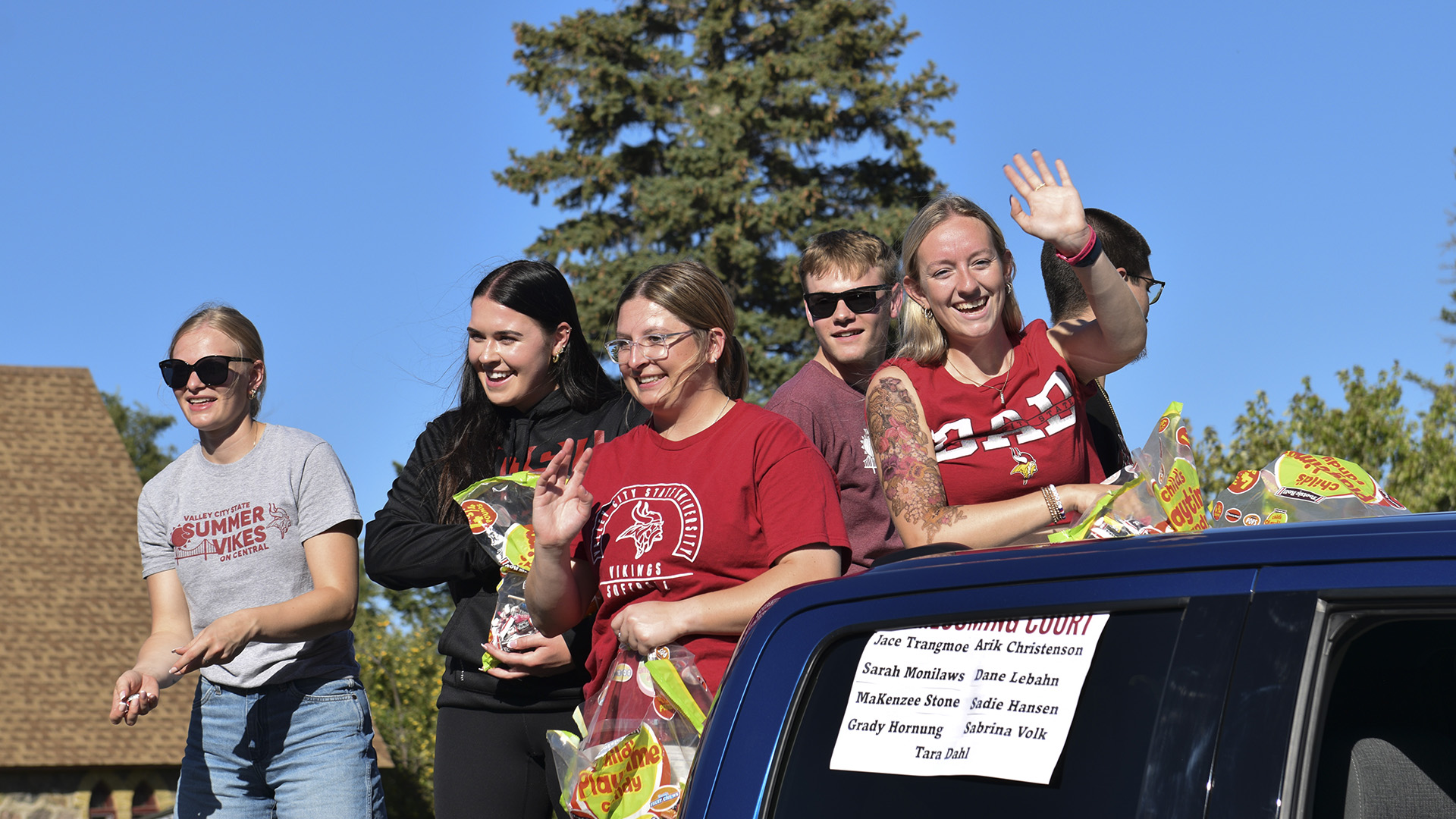 VCSU student ride in the back of a pickup and throw candy during the Homecoming parade.