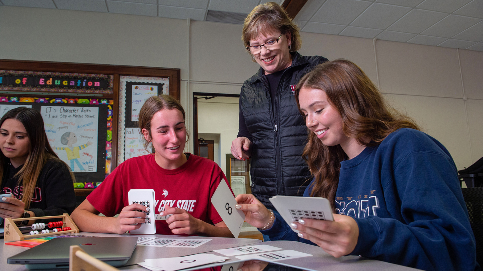 VCSU students and an instructor do a hands-on activity with flash cards.