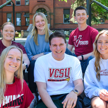 VCSU students sit on the steps in front of McFarland Hall.