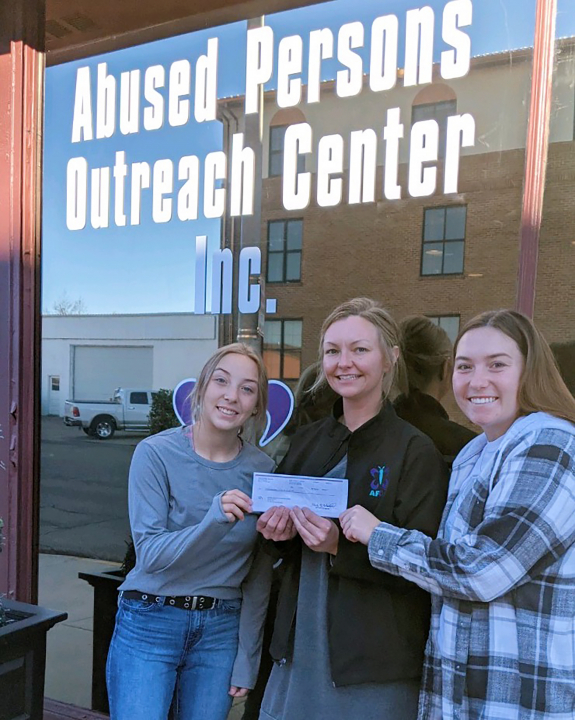 Two female VCSU students and a female APOC employee standing in front of the APOC building