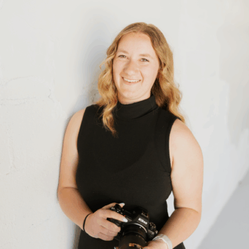 Alyssa Thomsen holding a camera smiling at the camera