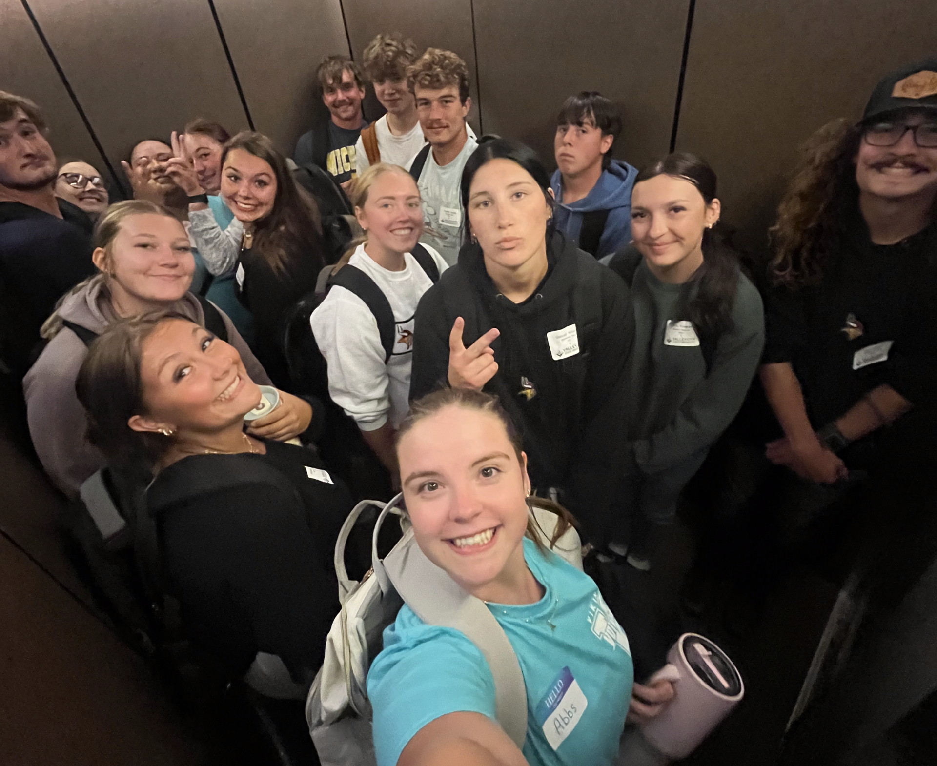 Abby Hill and a group of male and female students smiling at the camera