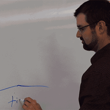 Biology teacher Nicholas Gault drawing on the board in a biology lab.