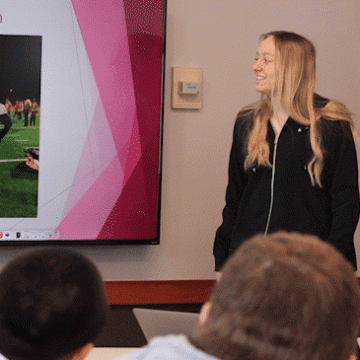 A communications student presents in class to fellow students