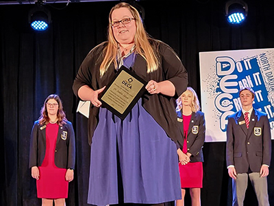 Amber Aberle holding award on stage